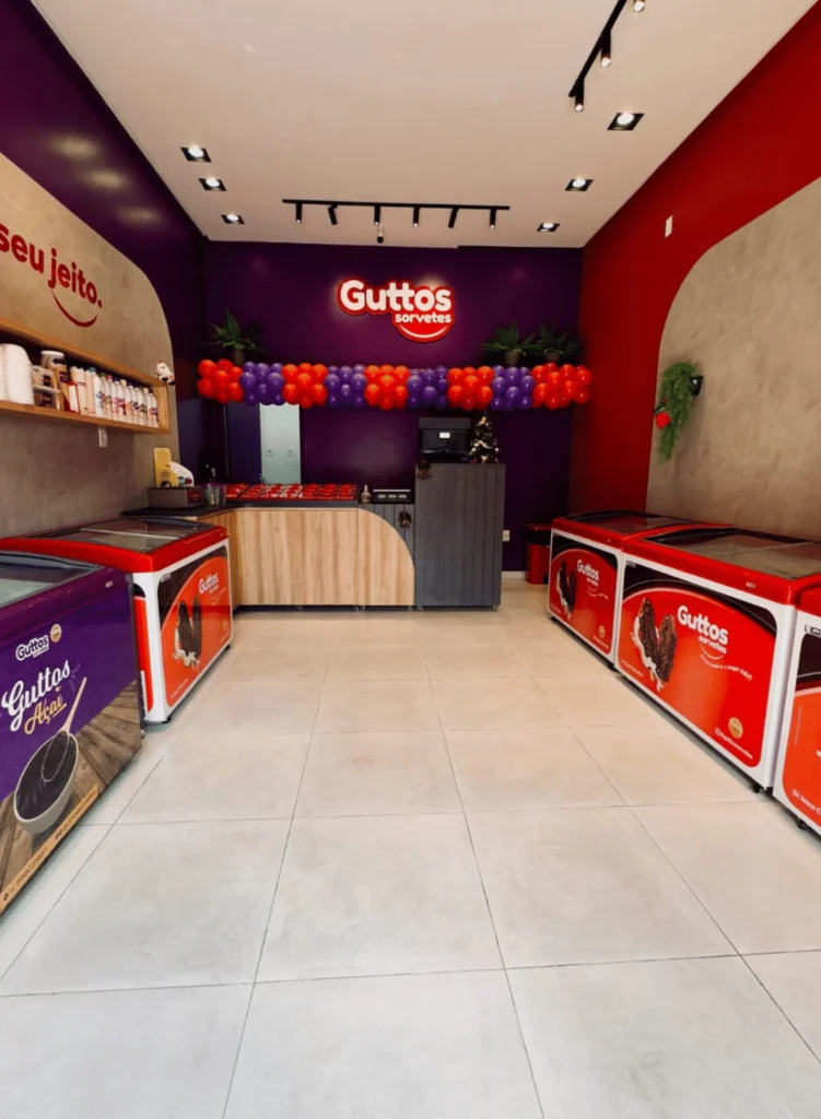 Interior de uma sorveteria Guttos, com freezers e balcão
